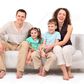 Family sitting on white leather sofa