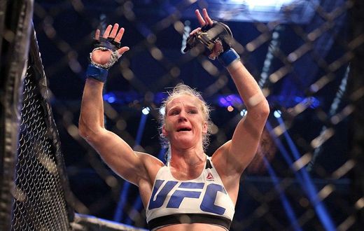 Holly Holm celebrates with her UFC belt after beating Ronda Rousey