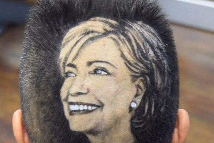 Maria Anita Monsivaiz shaves the face of Hillary Clinton on to her head