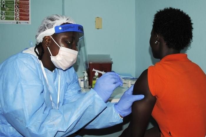 A health worker injects a woman with an Ebola vaccine during a trial in Monrovia, February 2, 2015. REUTERS/James Giahyue (LIBERIA - Tags: DISASTER HEALTH)