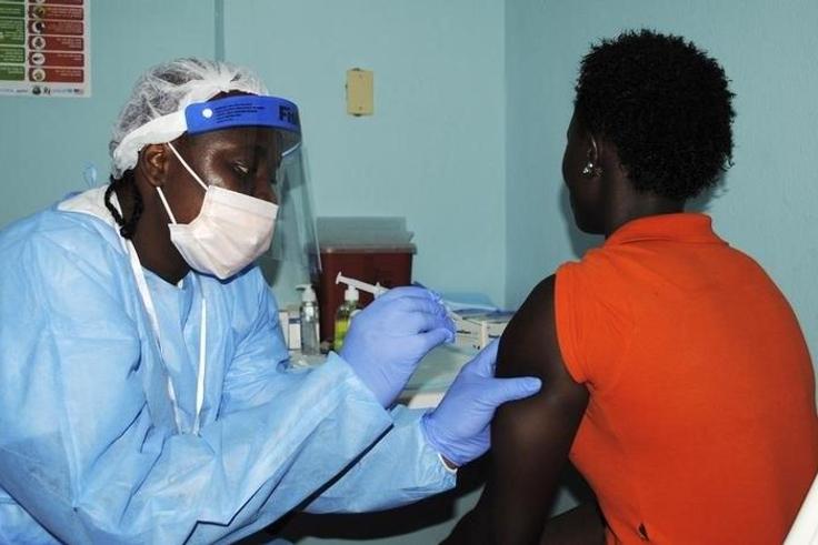 A health worker injects a woman with an Ebola vaccine during a trial in Monrovia, February 2, 2015. REUTERS/James Giahyue