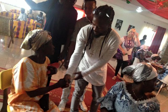 Samini donating his Xmas gift to the aged at Aya Community Clinic
