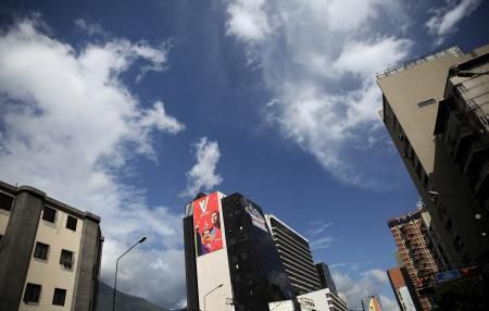 A banner (in red) with the images of Venezuela"s President Nicolas Maduro and late Venezuelan President Hugo Chavez, is pictured on a wall of a building in Caracas, December 5, 2015.
