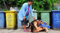 Beauty queen, Khanittha 'Mint' Phasaeng bows before her mum next to a row of wheelie bins