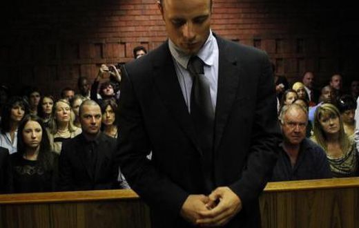 Oscar Pistorius stands in the dock ahead of court proceedings at the Pretoria magistrates court February 22, 2013.