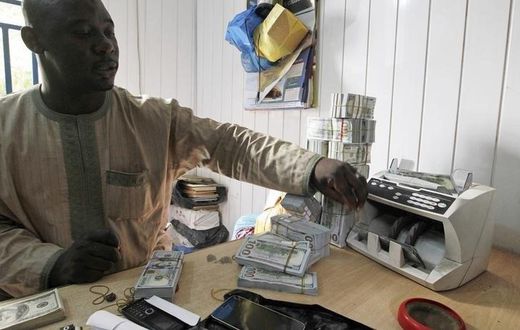 A bureau de change operator counts U.S. hundred dollar notes in Abuja, March 12, 2015. In Nigeria, holding naira has become increasingly unpopular as it has lost its value.  REUTERS/Afolabi Sotunde