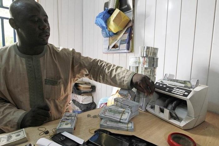 A bureau de change operator counts U.S. hundred dollar notes in Abuja, March 12, 2015. In Nigeria, holding naira has become increasingly unpopular as it has lost its value.  REUTERS/Afolabi Sotunde