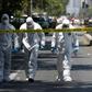 Police bomb squad personnel inspect the scene after a blast at a bus stop injured at least four people in downtown Santiago