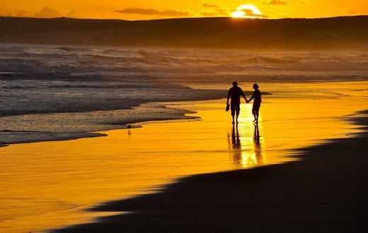 Couple taking a romantic walk on the beach at Sunset