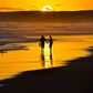 Couple taking a romantic walk on the beach at Sunset