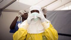 Health workers put on protective gear before entering a quarantine zone at a Red Cross facility in the town of Koidu, Kono district in Eastern Sierra Leone December 19, 2014. 
   REUTERS/Baz Ratner