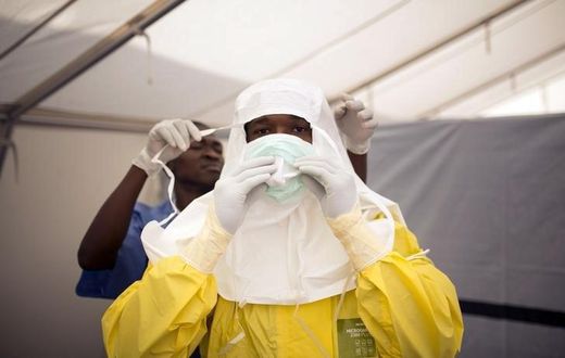 Health workers put on protective gear before entering a quarantine zone at a Red Cross facility in the town of Koidu, Kono district in Eastern Sierra Leone December 19, 2014. 
   REUTERS/Baz Ratner