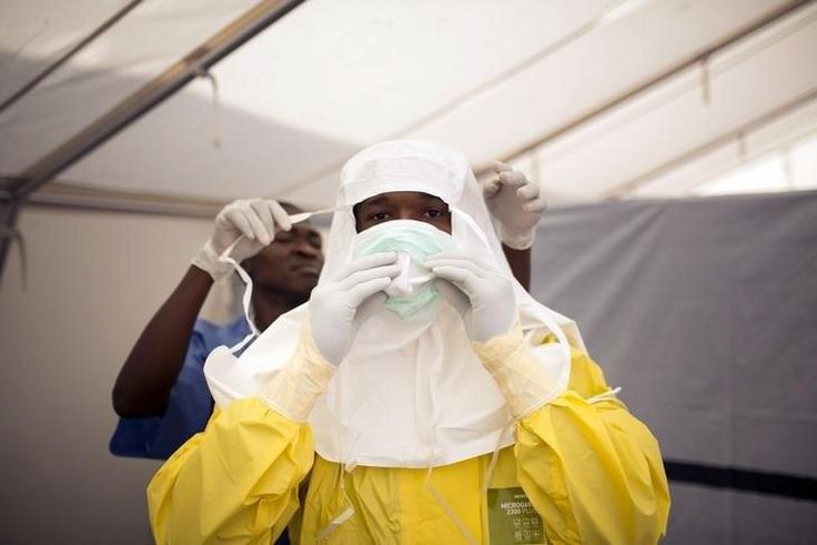 Health workers put on protective gear before entering a quarantine zone at a Red Cross facility in the town of Koidu, Kono district in Eastern Sierra Leone December 19, 2014. 
   REUTERS/Baz Ratner