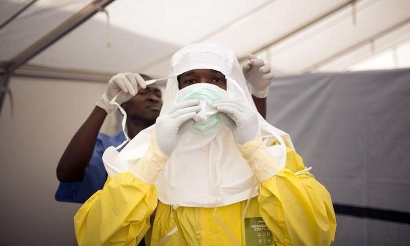Health workers put on protective gear before entering a quarantine zone at a Red Cross facility in the town of Koidu, Kono district in Eastern Sierra Leone December 19, 2014. 
   REUTERS/Baz Ratner