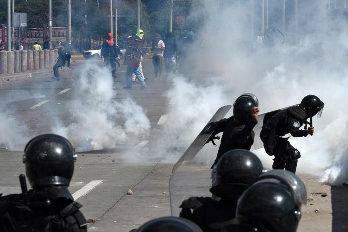 Riot police fire tear gas at Honduran students demanding the resignation of President Juan Orlando Hernandez in Tegucigalpa