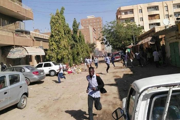 Sudanese protesters run away from tear gas during a demonstration in Khartoum on December 31, 2018