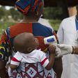 A health worker checks the temperature of a baby entering Mali from Guinea at the border in Kouremale, October 2, 2014.   REUTERS/Joe Penney