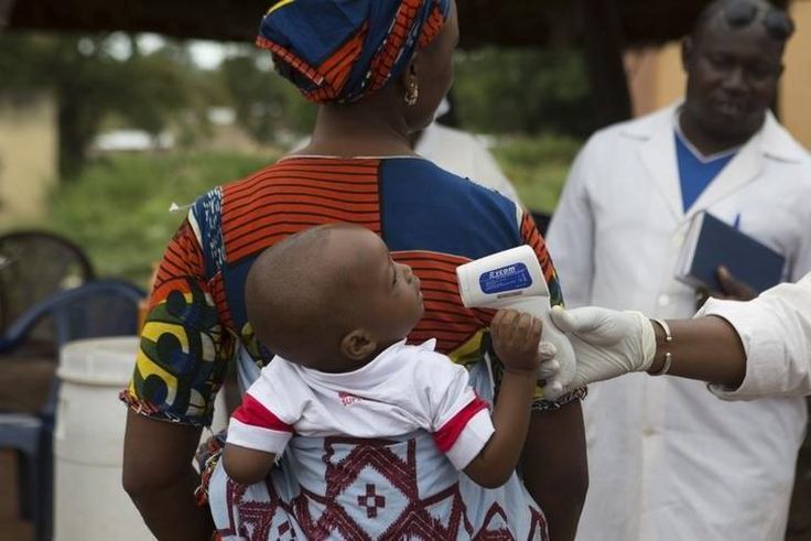 A health worker checks the temperature of a baby entering Mali from Guinea at the border in Kouremale, October 2, 2014.   REUTERS/Joe Penney