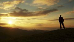 Male silhouette watching the rising sun