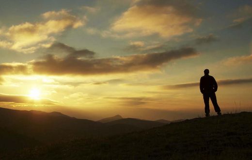 Male silhouette watching the rising sun