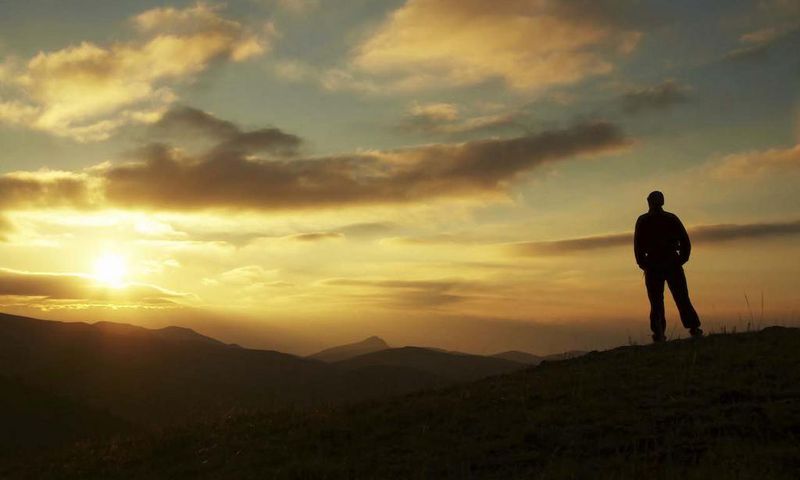 Male silhouette watching the rising sun
