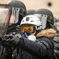 A French police officer aims a "defensive ball launcher" - known by its French initials "LBD" - at protesters during a "yellow vest" demonstration in Paris