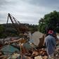 People look at a firefighter helicopter flying over the mud-hit area a day after the collapse of a dam at an iron-ore mine belonging to Brazil's giant mining company Vale near the town of Brumadinho, Brazil on January 26, 2019