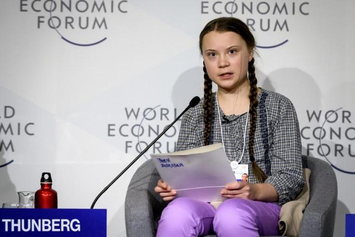 Swedish youth climate activist Greta Thunberg (C) delivers a mesage on climate change at Davos that business executives called "moving" and "inspiring"