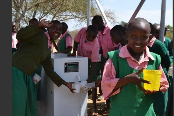 Kenyan school children making use of the ATM-like water solutions
