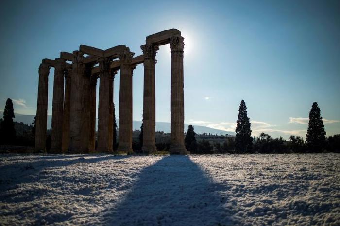 The ancient Temple of Zeus towers over an unusual blanketing of snow on Athens' Acropolis