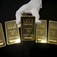 An employee poses for photographs with gold bars at the Korea Gold Exchange in Seoul, South Korea, July 31, 2015. REUTERS/Kim Hong-Ji/Files
