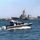 Yemeni marine police patrol around the damaged destroyer USS Cole as it is towed out of Aden harbor on October 29, 2000 -- US President Donald Trump has confirmed that a key plotter of the attack was killed in a US air strike