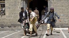 Yemenis carry a body of a man killed in a bomb attack in a mosque in Sanaa, Yemen, Friday, March 20, 2015.