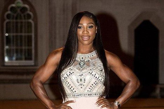 Serena Williams shows of her toned figure in a peach floor length dress