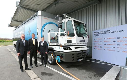 Officials of both comanies with the all-electric truck