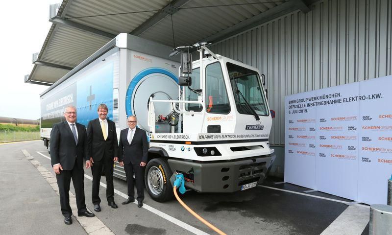 Officials of both comanies with the all-electric truck