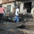 People walk past a burnt house in Nigeria's central Plateau State's capital Jos, November 30, 2008