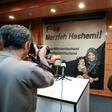 Journalists in Tehran photograph and film a poster calling for the release of Marzieh Hashemi, a US-born presenter for Iran's Press TV who was arrested on a visit to her birth country