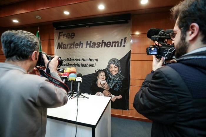 Journalists in Tehran photograph and film a poster calling for the release of Marzieh Hashemi, a US-born presenter for Iran's Press TV who was arrested on a visit to her birth country