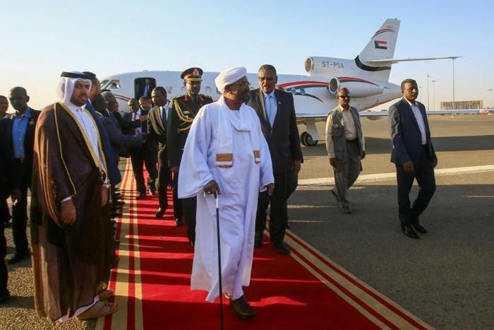 Sudan's President Omar al-Bashir (C) is received upon his return from Qatar at Khartoum international airport