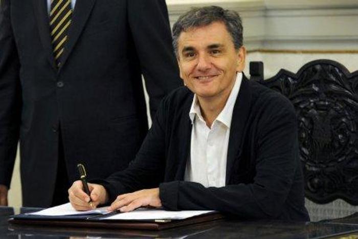 Newly appointed Greek Finance Minister Tsakalotos signs official documents following a swearing-in ceremony at the presidential palace in Athens