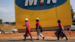 Protesters walk past an MTN logo during a strike of about 2,000 MTN workers outside the company's headquarters in Johannesburg, May 20 2015. REUTERS/Siphiwe Sibeko