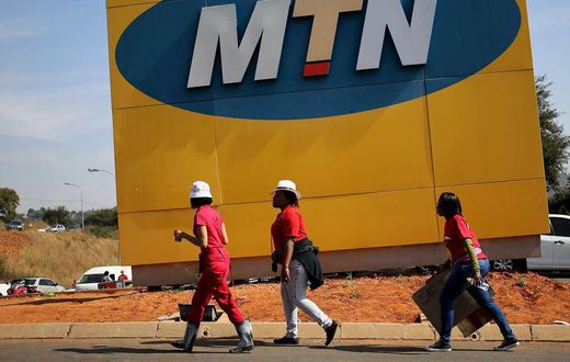 Protesters walk past an MTN logo during a strike of about 2,000 MTN workers outside the company's headquarters in Johannesburg, May 20 2015. REUTERS/Siphiwe Sibeko