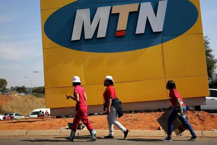 Protesters walk past an MTN logo during a strike of about 2,000 MTN workers outside the company's headquarters in Johannesburg, May 20 2015. REUTERS/Siphiwe Sibeko