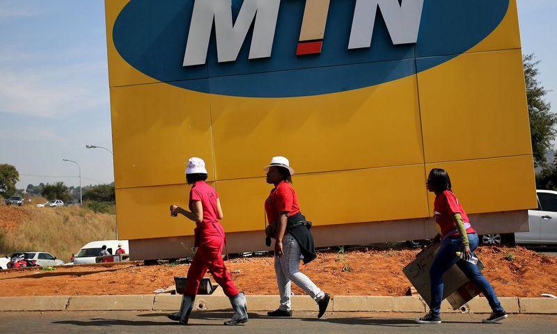 Protesters walk past an MTN logo during a strike of about 2,000 MTN workers outside the company's headquarters in Johannesburg, May 20 2015. REUTERS/Siphiwe Sibeko