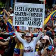 A woman holds a poster demanding free elections during an opposition rally against leader Nicolas Maduro