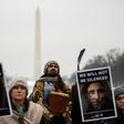 Activists hold up signs as they listen to speakers during the Indigenous People's March on the National Mall in Washington, DC,