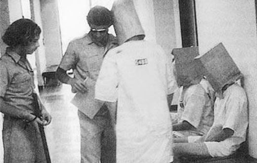 Guards humiliating a prisoner