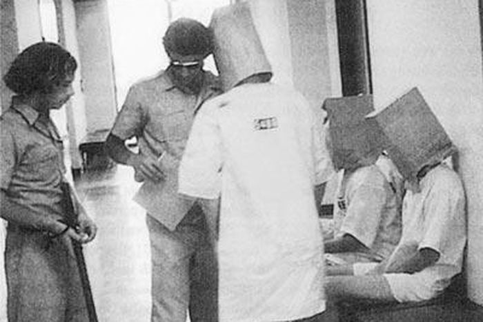 Guards humiliating a prisoner