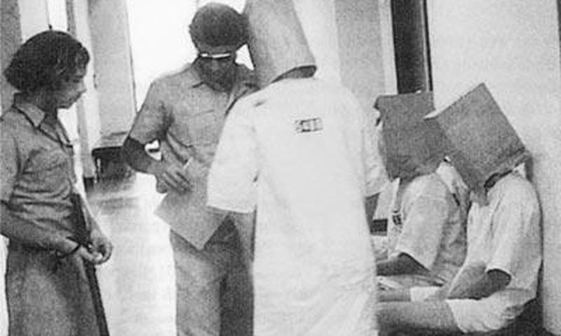 Guards humiliating a prisoner